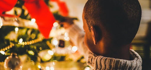 young boy puts holiday decorations on tree KHM Attorneys at Law Colorado Springs, Castle Rock