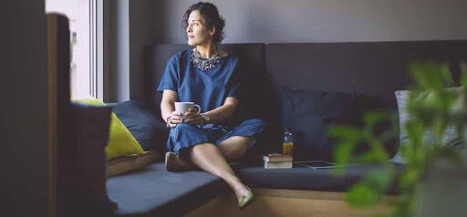 woman sits on couch thinking about her high net worth pending divorce KHM Attorneys at Law Colorado Springs, Castle Rock