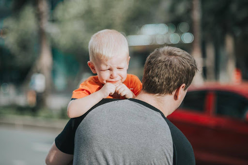 father carries upset son to a car KHM Attorneys at Law Colorado Springs, Castle Rock