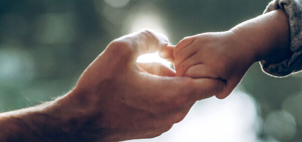 hero image close up of child hanging on to father's finger KHM Attorneys at Law Colorado Springs, Castle Rock